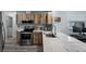 Updated kitchen features stainless steel appliances, stone countertops, wood cabinets, and modern fixtures at 3355 Roslyn Rd, Venice, FL 34293