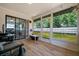 Cozy screened lanai with stylish wood-look flooring, offering a tranquil view of the spacious backyard and patio at 3355 Roslyn Rd, Venice, FL 34293