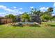 Large backyard with manicured lawn, palm trees, and screened pool at 348 Dorchester Dr, Venice, FL 34293