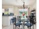 Bright dining area with glass table and chairs, view of backyard pool, chandelier, and breakfast bar at 348 Dorchester Dr, Venice, FL 34293