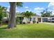 Beautiful single-story home with a lush lawn, mature trees, and well-maintained landscaping at 348 Dorchester Dr, Venice, FL 34293