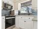Well-lit kitchen with stainless steel oven, dishwasher, faucet, and a blue-tiled backsplash at 348 Dorchester Dr, Venice, FL 34293