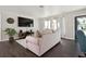 Cozy living room featuring a large wall-mounted TV, hardwood floors, and two large windows at 348 Dorchester Dr, Venice, FL 34293