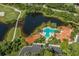 Aerial view of the community pool, pond, golf course, roads and lush landscaping at 353 Marsh Creek Rd, Venice, FL 34292