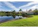 Rear exterior view of a home showcasing water views and lush landscaping from the backyard at 353 Marsh Creek Rd, Venice, FL 34292