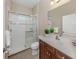 Well-lit bathroom featuring glass enclosed walk-in shower, a single sink vanity, and neutral tones at 353 Marsh Creek Rd, Venice, FL 34292
