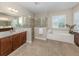 Spa-like bathroom featuring a large shower, soaking tub, double vanity, and neutral tones at 353 Marsh Creek Rd, Venice, FL 34292