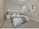 Well-lit bedroom with queen bed, blanket, side tables, and white wicker headboard at 353 Marsh Creek Rd, Venice, FL 34292