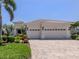 Charming home features a three-car garage, tile roof, and lush landscaping at 353 Marsh Creek Rd, Venice, FL 34292