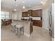 Modern kitchen features granite counters, wood cabinets, stainless steel appliances, and a convenient breakfast bar at 353 Marsh Creek Rd, Venice, FL 34292