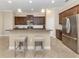 Bright kitchen featuring granite counters, stainless steel appliances, wood cabinets, and seating at the breakfast bar at 353 Marsh Creek Rd, Venice, FL 34292