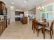 Open concept kitchen featuring granite counters, stainless appliances, wood cabinets, and adjacent dining area at 353 Marsh Creek Rd, Venice, FL 34292