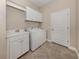 Functional laundry room with white cabinets, a utility sink, and a full-size washer and dryer at 353 Marsh Creek Rd, Venice, FL 34292