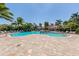 Large community pool with waterfall feature surrounded by lush landscaping and lounge seating at 353 Marsh Creek Rd, Venice, FL 34292