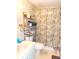 Modest bathroom with tile floor features a vanity, toilet, shelving, and shower curtain at 358 Longwood Dr, Venice, FL 34285