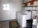 Laundry room with washer, dryer, shelving, and adjacent window for light at 358 Longwood Dr, Venice, FL 34285