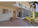 Condo exterior with screened-in porch, decorative door, and well-maintained landscaping at 360 Base E Ave # 413, Venice, FL 34285