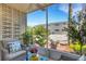 Relaxing screened patio featuring wicker chairs, colorful pillows, and a view of lush greenery at 360 Base E Ave # 413, Venice, FL 34285