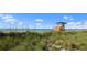 Beautiful beach with a lifeguard tower surrounded by dune grass under a blue sky at 400 Base # 225, Venice, FL 34293