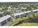 Scenic aerial view of condo buildings surrounded by lush landscaping, water features, and golf course at 406 Cerromar N Cir # 128, Venice, FL 34293