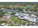 Stunning aerial view showcasing community clubhouse, pools, tennis courts, and meticulously landscaped grounds at 406 Cerromar N Cir # 128, Venice, FL 34293