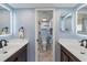 Stylish bathroom featuring double sinks, wood cabinets, modern mirrors, and a tiled shower at 406 Cerromar N Cir # 128, Venice, FL 34293