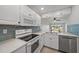 Bright kitchen features white cabinets, modern appliances, tile backsplash and breakfast bar overlooking the dining area at 406 Cerromar N Cir # 128, Venice, FL 34293