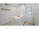 Bright kitchenette with white cabinetry, solid surface counters and small island, tile flooring at 406 Cerromar N Cir # 128, Venice, FL 34293