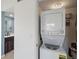 Convenient laundry area with stacked washer and dryer, and a view into the adjacent bathroom at 406 Cerromar N Cir # 128, Venice, FL 34293