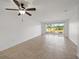Open living area with tile floors and sliding glass doors that open to a screened lanai with views of the golf course at 406 Cerromar N Cir # 128, Venice, FL 34293