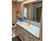 Traditional bathroom featuring blue countertops, decorative wallpaper, and mirror over the sink at 411 Cervina N Dr # 493, Venice, FL 34285