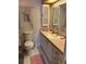Vintage bathroom featuring wallpaper, pink countertops, white cabinets and a toilet at 411 Cervina N Dr # 493, Venice, FL 34285
