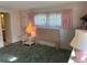 Bedroom with pink curtains, wicker furniture and view to a bathroom at 411 Cervina N Dr # 493, Venice, FL 34285