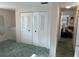 Bright bedroom featuring closet with louvered doors and a view of living area at 411 Cervina N Dr # 493, Venice, FL 34285