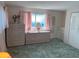 Spacious bedroom featuring plush green carpet, pink curtains, and matching dressers at 411 Cervina N Dr # 493, Venice, FL 34285