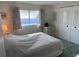 A bedroom featuring a bed and a window with floral curtains and a closet with louvered doors at 411 Cervina N Dr # 493, Venice, FL 34285