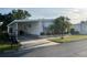 Inviting single-story home with a covered carport, awning accents, and well-maintained landscaping at 411 Cervina N Dr # 493, Venice, FL 34285