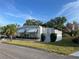 Charming single-story home features a covered awning, decorative shrubs, and well-kept lawn at 411 Cervina N Dr # 493, Venice, FL 34285