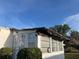 Single-story home with a covered extension featuring multiple windows and a visible repair tarp at 411 Cervina N Dr # 493, Venice, FL 34285