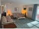 Cozy living room featuring floral pattern furniture, carpet, lamps, and natural light through sliding door at 411 Cervina N Dr # 493, Venice, FL 34285