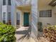 Inviting entrance to unit 103 featuring a bright turquoise door surrounded by lush landscaping and stone accents at 416 Laurel Lake Dr # 103, Venice, FL 34292