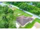 Aerial view of a yellow home with brown roof surrounded by verdant trees at 431 Sevilla St, North Port, FL 34287