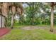 Landscape view of the yard behind the house with mature trees and brush at 431 Sevilla St, North Port, FL 34287