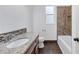 Bathroom featuring granite counters, warm cabinetry, and a shower and tub with tiled surround at 431 Sevilla St, North Port, FL 34287