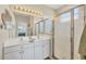 Bright bathroom with double vanity, large mirror, and glass-enclosed shower at 4427 Blue Heron Cir, North Port, FL 34287
