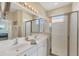 Bright bathroom with double vanity, large mirror, and glass-enclosed shower at 4427 Blue Heron Cir, North Port, FL 34287