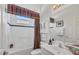 Bathroom features colorful curtains, white cabinets, and tub/shower combo at 4427 Blue Heron Cir, North Port, FL 34287
