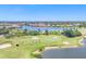 Scenic view of a golf course with a lake and beautiful homes at 4427 Blue Heron Cir, North Port, FL 34287