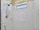 Clean, bright shower features white tile, window, and convenient grab bar at 4427 Blue Heron Cir, North Port, FL 34287