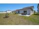 An open backyard has green grass, a small tree, and a patio set on a concrete patio at 4523 Birdsong Dr, Palmetto, FL 34221